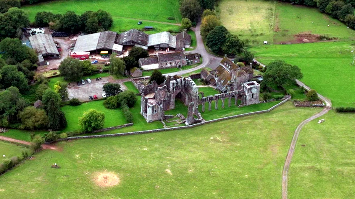 Aerial view of the Llanthony Priory ruins among farm buildings and green fields